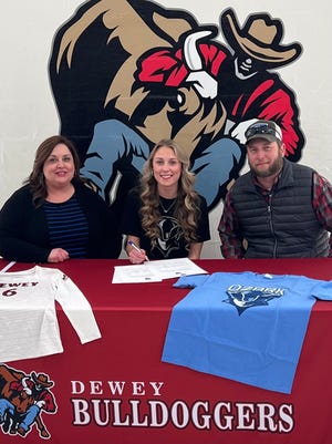 Dewey High School volleyball player Savanna Serafin, center, is joined by parents Jessica and Mark while she signs her letter of intent to play at Ozark Christian College.