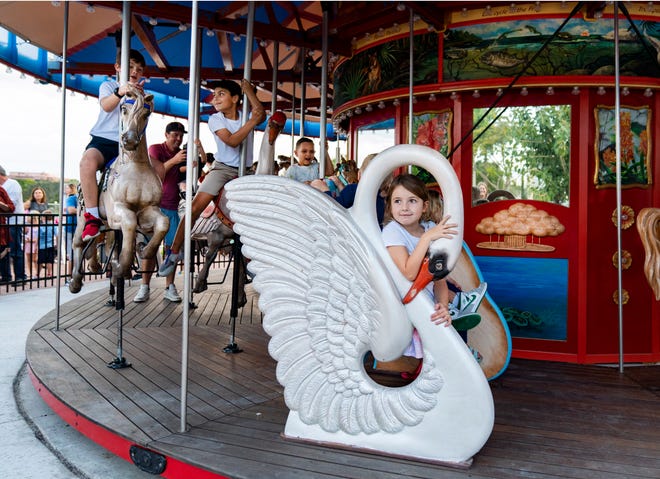 Children ride the carousel iat Downtown Palm Beach Gardens before it was dismantled and shipped away to be refurbished for a second time.