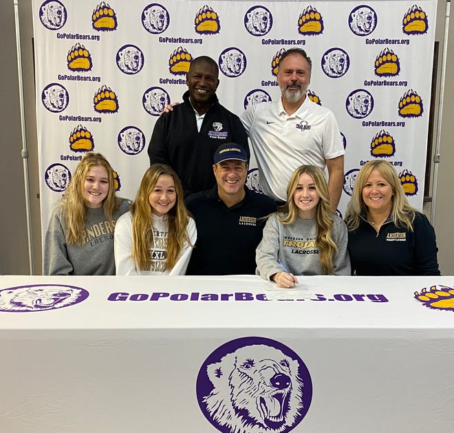 Jackson High School lacrosse player Mackenzie Adams is joined by her family and Polar Bears coaches Mike Peterson and John Kroah as she signs her national letter of intent with Anderson University.