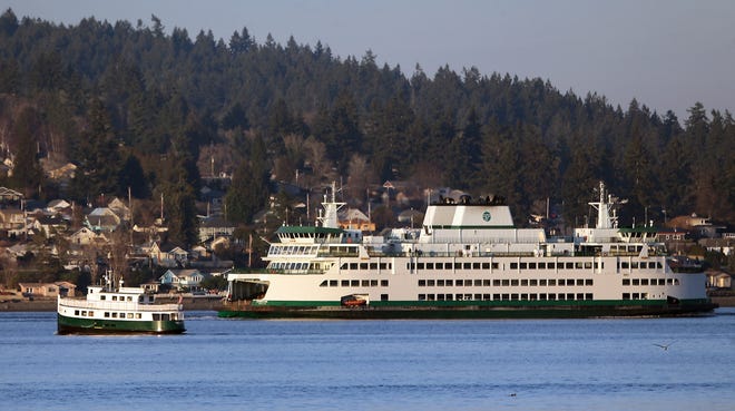 FILE PHOTO - Kitsap Transit's Carlisle II heads for Bremerton while the Washington State Ferries vessel Chimacum heads for Seattle on Jan. 26.