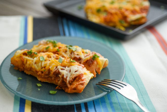 Vegan Enchiladas are topped with vegan cheese and have a seasoned tofu filling.