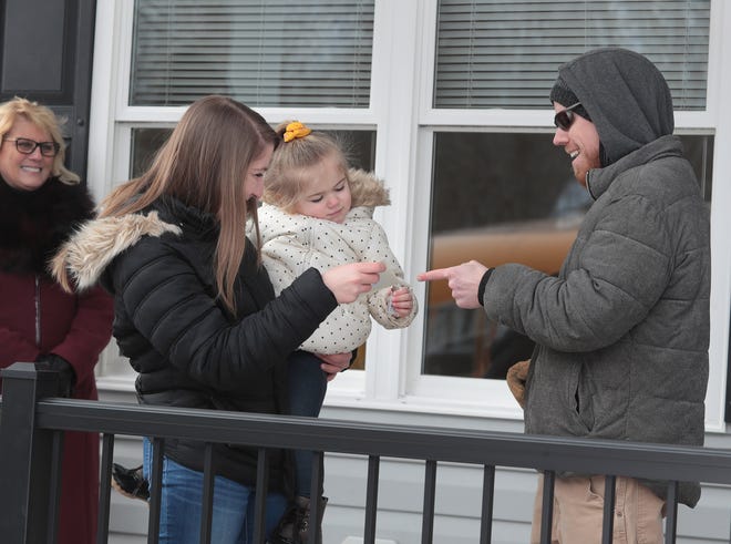 New homeowner, Kayla Newman, and her 3-year-old daughter, Annalee Williams, are handed the keys to their new home. The Habitat for Humanity home at 1311 13th St. SE, was constructed by the juniors and seniors in the Washington High School construction trades program.