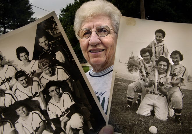 Eleanor "Rudy" Rudolph poses in 2005 with photos from her days with the Pekin Lettes. Rudolph, kneeling in the team photo at right — and a fixture in the softball community from Peoria to Springfield — died this month at age 93.