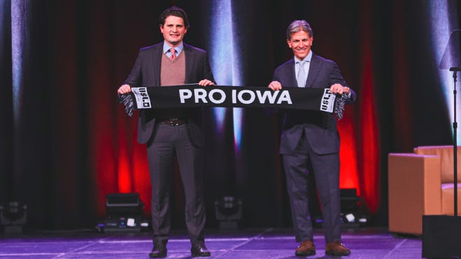Kyle Krause and USL Chief Operating Officer Justin Papadakis pose with a Pro Iowa soccer scarf at the Greater Des Moines Partnership Annual Dinner on Jan.  27, 2022.