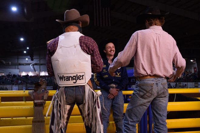 Cowboys hang out above pens before the Southern Miss Coca-Cola Classic Rodeo in Hattiesburg, Miss., on Friday, Jan. 28, 2022.
