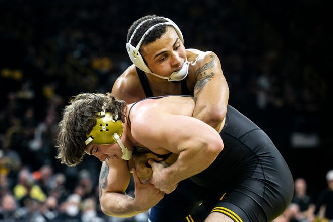 Penn State's Aaron Brooks, top, wrestles Iowa's Abe Assad at 184 pounds during a Big Ten Conference dual meet Friday night at Carver-Hawkeye Arena in Iowa City, Iowa.