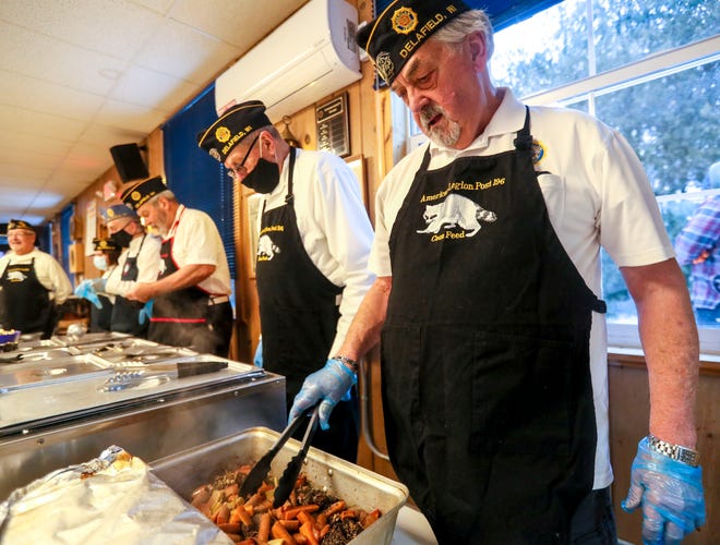 Mike Proulx serves the slow-roasted raccoon during the 95th Coon Feed in 2022.