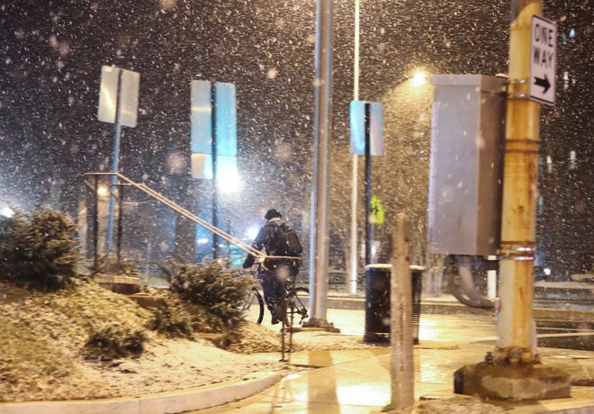 A bicyclist rolls through the intersection of Pennsylvania Avenue and N. Van Buren Street as snow falls in Wilmington early Friday evening, Jan. 28, 2022.