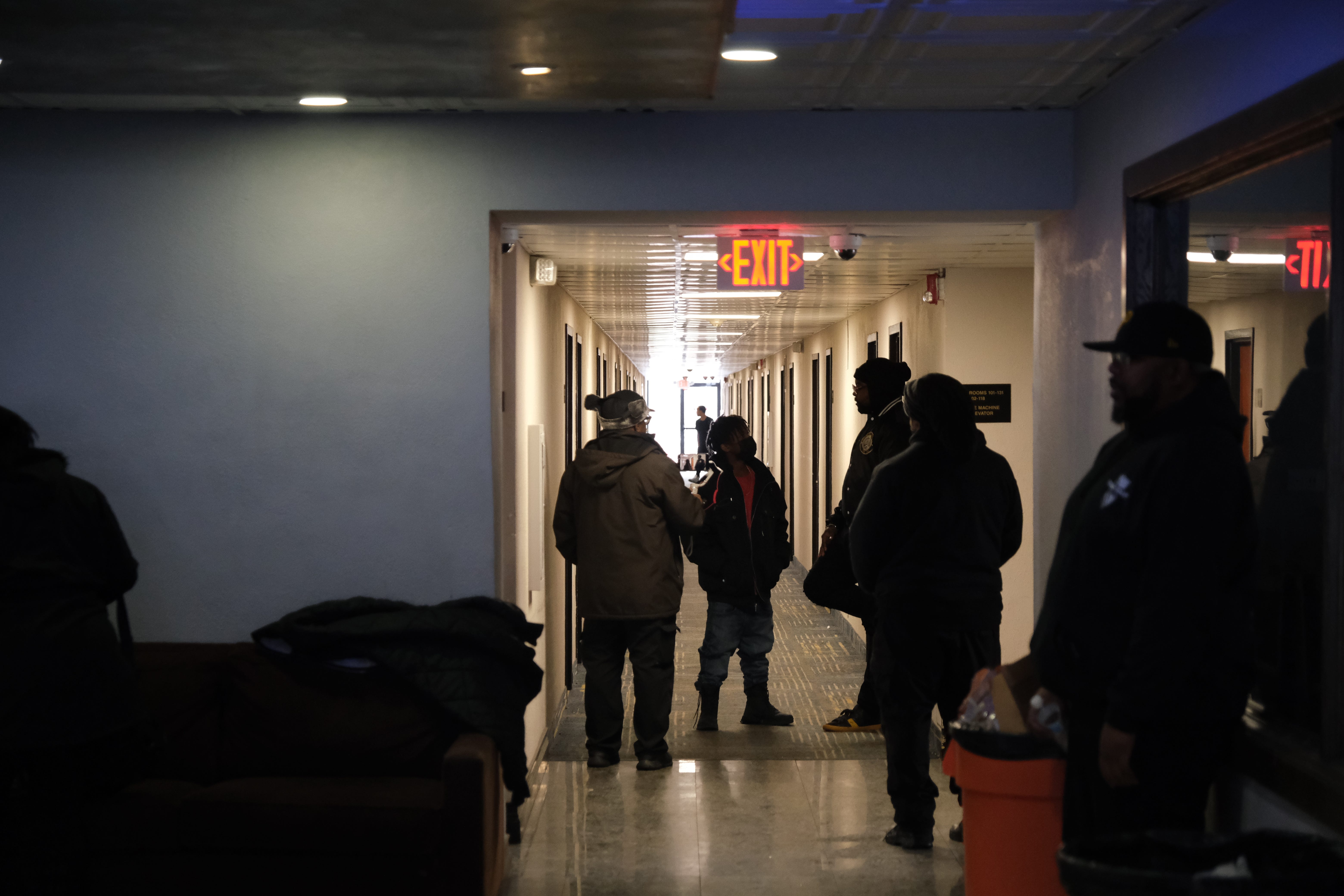 Zeek Williams, background, founder of New Era Detroit, speaks with some of the people for whom the nonprofit bought a night's stay at the Baymont by Wyndham hotel in Ferndale on Sunday.