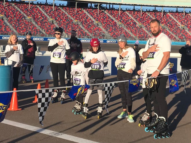Lyndsey Fry (172) and the Accardo family listen to the national anthem during the second annual "Skatin' for Leighton" event on Jan. 30, 2022, at Phoenix Raceway.