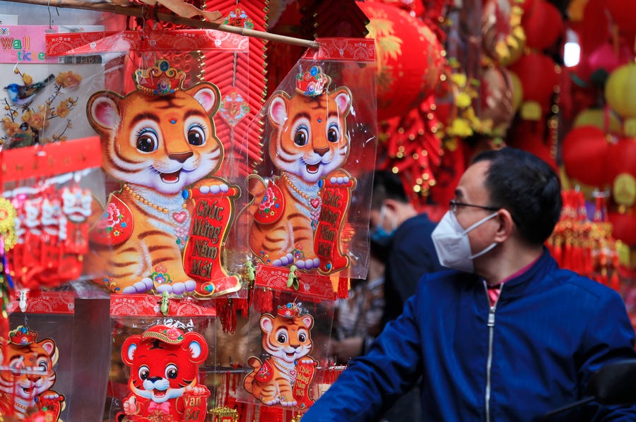 A man looks at decorative cut-outs of tigers at the traditional Lunar New Year "Tet" market in the old quarter of Hanoi, Vietnam, Friday, Jan. 28, 2022.