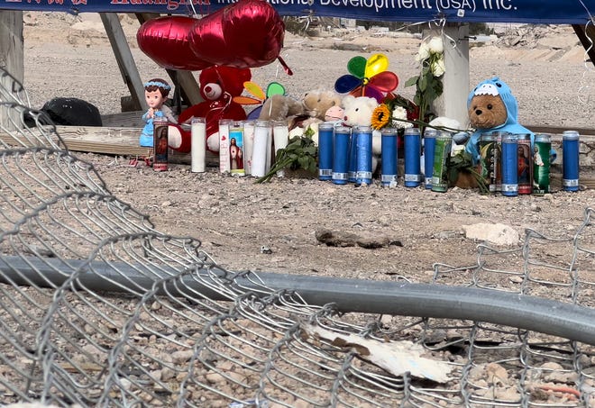 A mangled chainlink fence damaged in a "mass casualty" car crash gives way to a makeshift memorial on Monday, Jan. 31, 2022, at the intersection of Commerce Street and Cheyenne Avenue in North Las Vegas. The crash two days earlier claimed the lives of nine people, including seven family members.
