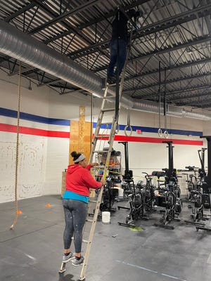Norwich Fitness Center members and coaches Jada Goodwin and Steve Manfredi help take down gymnastics rings in the gym on Friday, preparing for the move to Summit Fitness.
