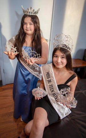 Sisters Alexus Her, 9, and her sister Angel, 13,  pose with tiaras that they have earned in competition in Little Miss Nation and Little Miss Teen Nation pageants, Tuesday, February 1, 2022, in Manitowoc, Wis.