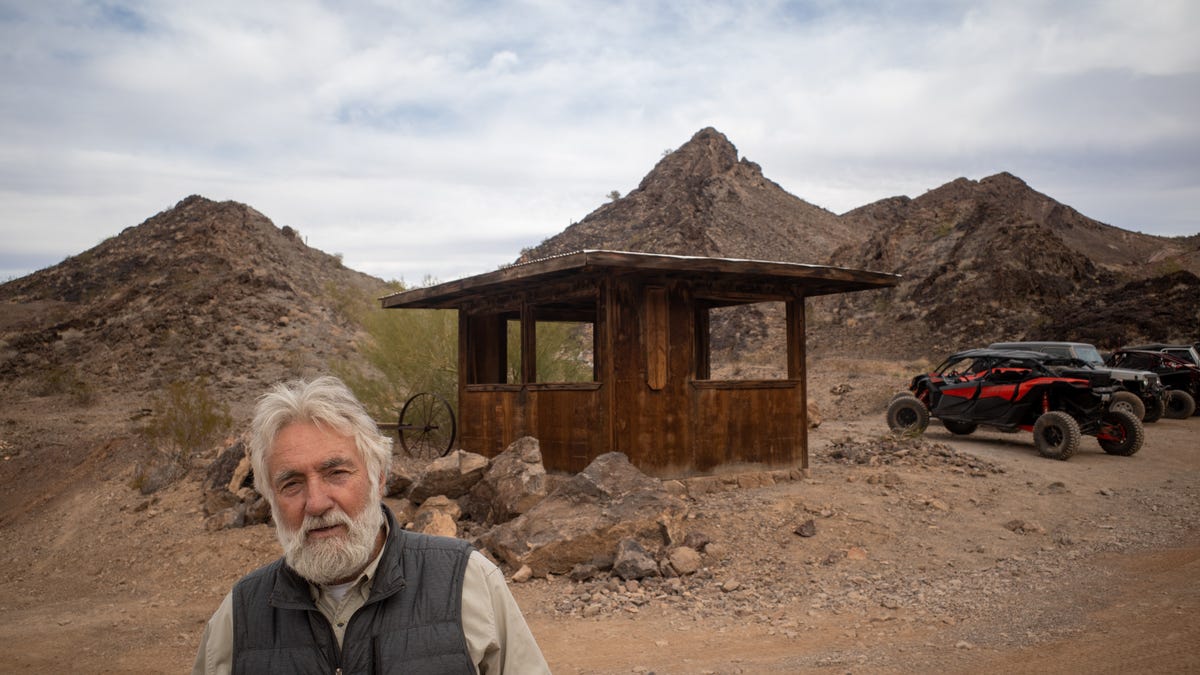 Ken Coughlin, owner of the Desert Bar poses for a photo in front of the original 5-seater outpost he built in the early 1980s.