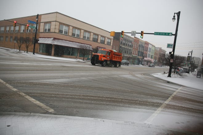 A snow plow salts Huron Avenue during a snowstorm predicted to bring six to nine inches of snow in the city of Port Huron on Wednesday, Feb. 2, 2022.