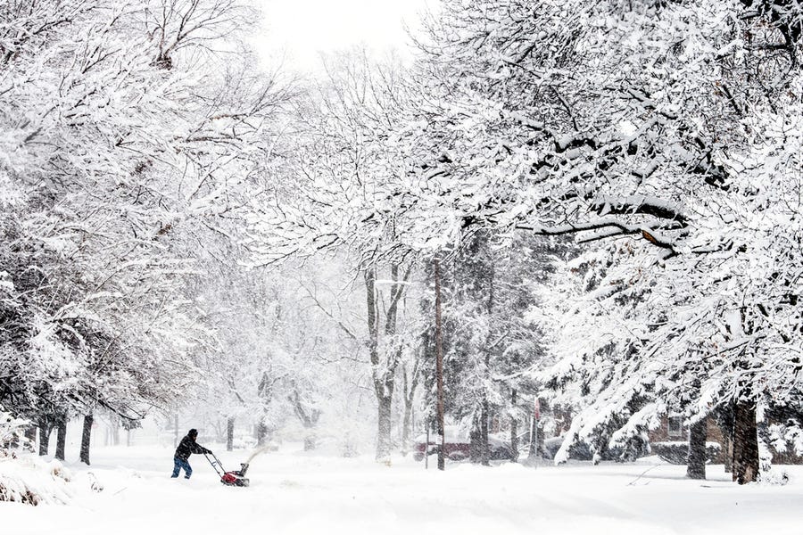Cory Pacheco, 58, uses a snowblower to clear off his driveway Feb. 2 in downtown Flint, Mich. He says he intends to continue to remove snow throughout a heavy storm. "I love it. It's truly so beautiful," he says, taking a break to admire the fresh blanket atop the trees. "We've needed this."