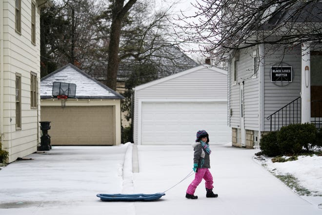 Eleanor Million, 6, pulls her sled around the block in Clintonville as Winter Storm Landon arrived Thursday.