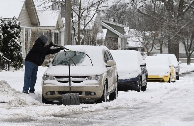 Tommy Moss of Ferndale brushes snow off his car along Spencer Street in Ferndale on Thursday, February 3, 2022.