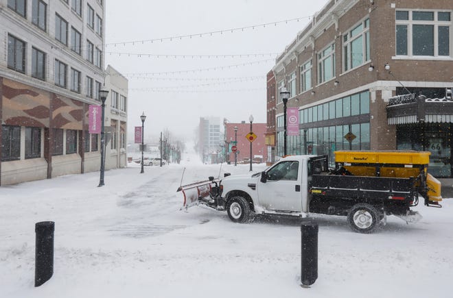 A snow plow pulls onto Boonville Avenue from Park Central Square in downtown Springfield on Thursday, Feb. 3, 2022.