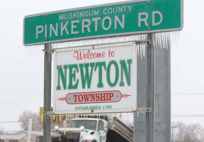 Ice clings to road signs as an ODOT plow passes by on Maysville Pike Thursday afternoon.