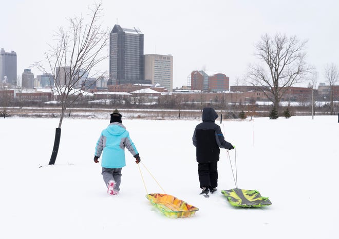 Sophia Frencho, 9, left, and her brother Jack, 11, walk their sleds to the hill at at Scioto Audubon Metro Park in Columbus on Friday.