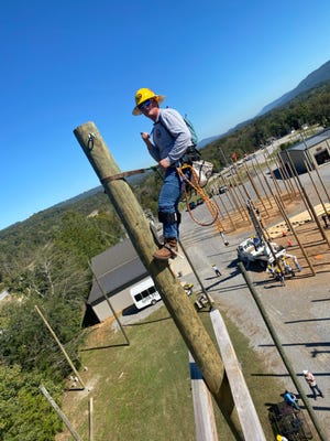 Owen Carey atop a 65-foot training pole at the Southeast Lineman Training Center.