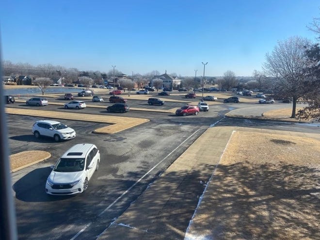 Cars weave through the extended route through the parking lot at West Jackson Baptist Church on their way to get boxes of free products from Tyson Foods.