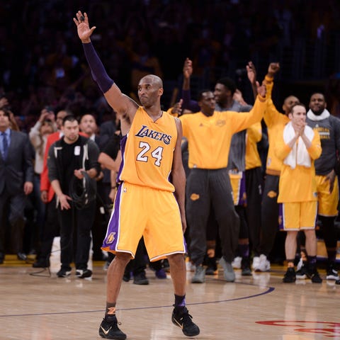 Kobe Bryant waves to the crowd as he heads to the 