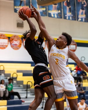 Stony Point's Josiah Moseley, right, tries to block a shot by Hutto's Joemori Francis in a District 25-6A contest Saturday at Stony Point High School. Stony Point won the game 65-53 to secure a playoff spot.