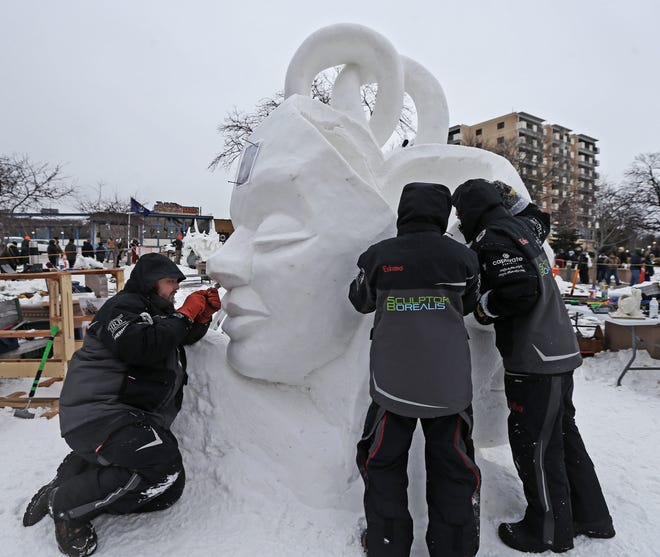 Joshua Jakubowski, from left, teammate Michael Lechtenberg and his son Robert Lechtenberg work on the Wisconsin snow sculpture titled “Deeper Connections” on Friday at the 2022 U.S. National Snow Sculpting Championship in Lake Geneva.