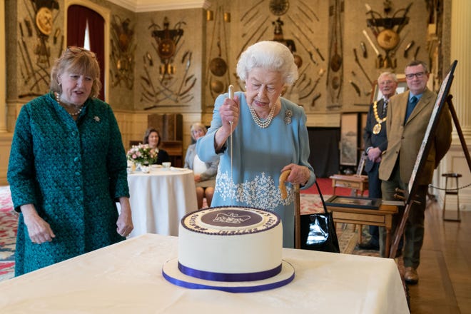Queen Elizabeth II cuts a cake to celebrate the start of the Platinum Jubilee during a reception in the Ballroom of Sandringham House on Feb.  5, 2022 in King's Lynn, England. 