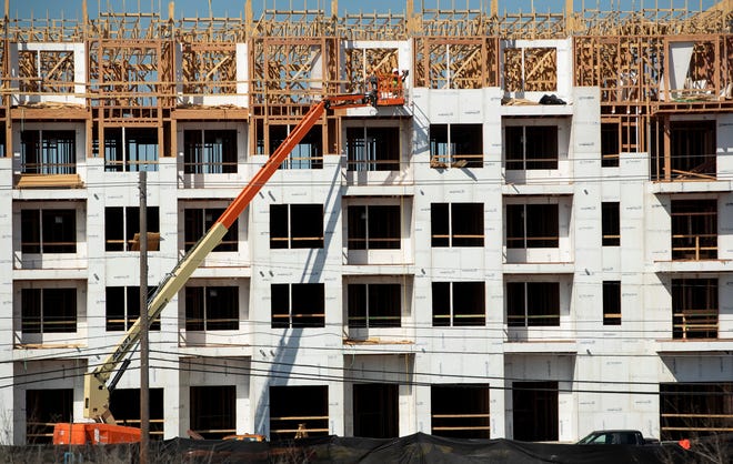 Workers construct the Urban East Apartments on East Riverside Drive on Monday February 7, 2022.  
