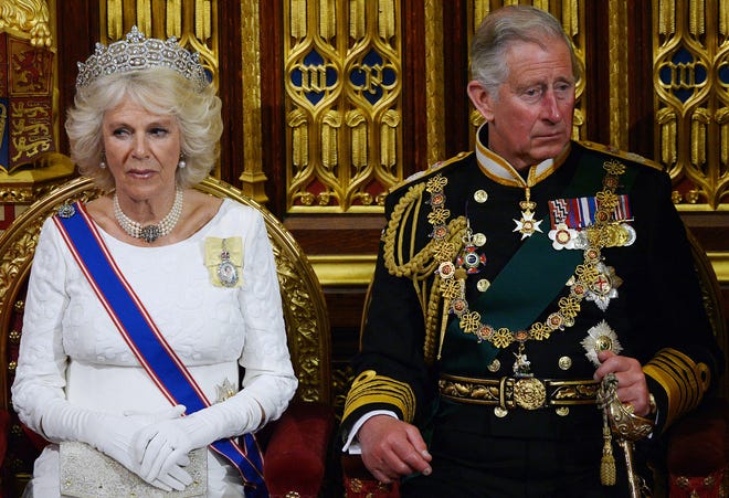 الأمير تشارلز وكاميلا ، دوقة كورنوال يستمعان إلى الملكة إليزابيث الثانية أثناء إلقاء خطاب الملكة في مجلس اللوردات في الافتتاح الرسمي للبرلمان في عام 2014.