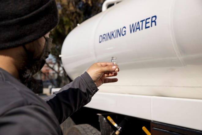 Austin Water pipeline technician Nicholas Escobar checks the chlorine level of a water sample at a water distribution site at the Austin Water North Service Center during a water boil notice on Tuesday February 8, 2022.  