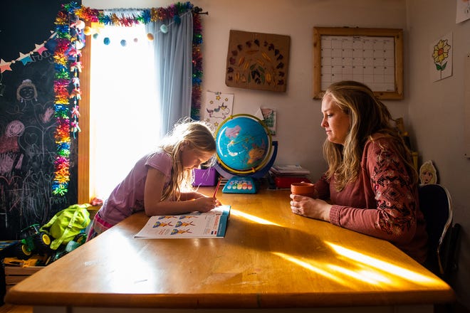 Aleksa Reichle, 5, left, and her mom Kassandra Reichle, right, use a workbook to learn about different countries during a homeschool lesson at their home in Walden, NY on Tuesday, February 8, 2022.