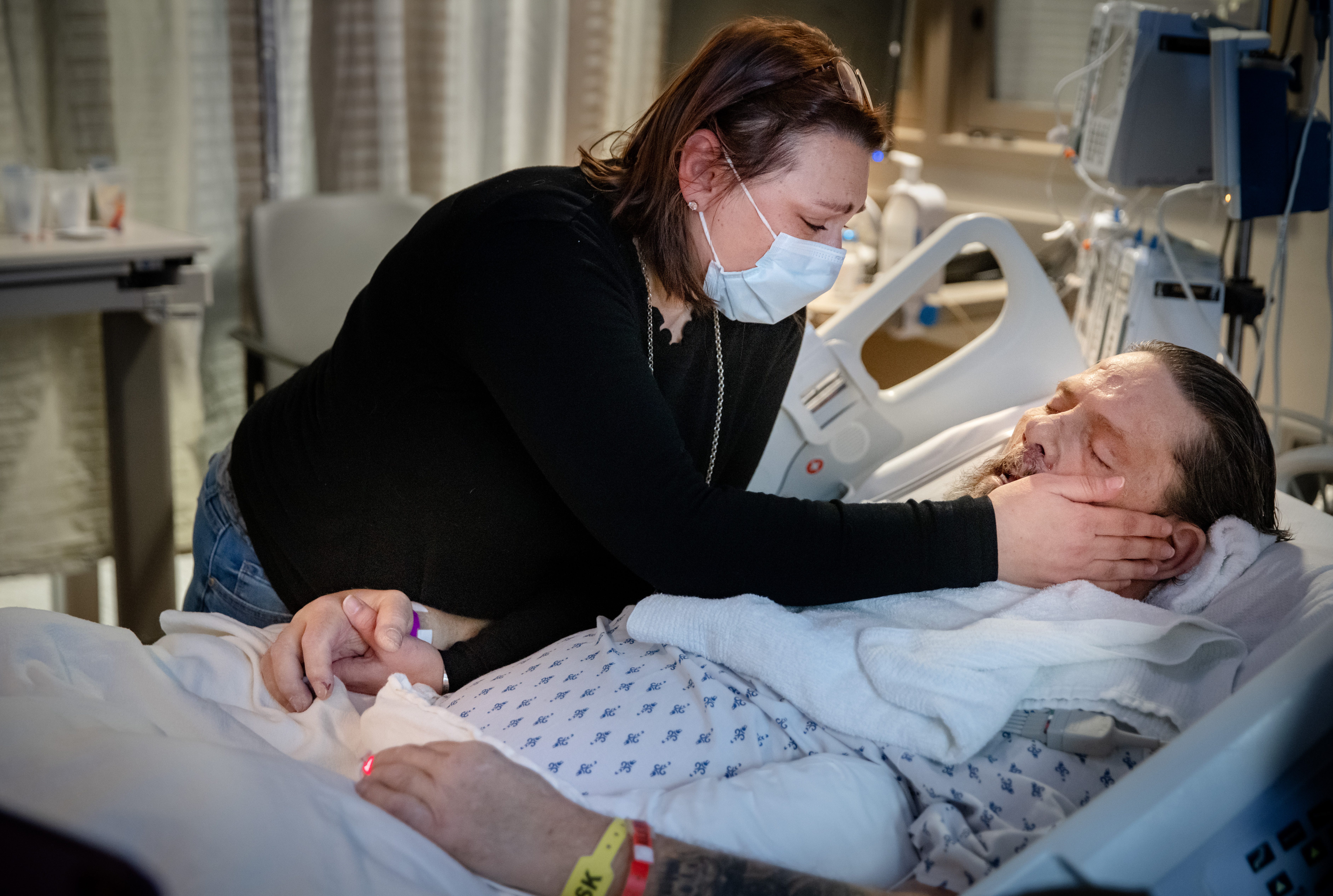 Jennifer caresses her father's cheek and holds his hand as he takes his last breaths after being taken off of a ventilator.