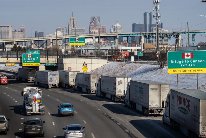 A small line of semi-trailer trucks line up along northbound I-75 in Detroit as the Ambassador Bridge entrance is blocked off for travel to Canada on February 8, 2022.