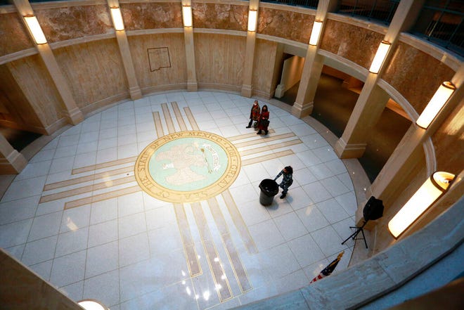 People walk under the state Capitol rotunda during the annual legislative session on Wednesday, Feb. 2, 2022, in Santa Fe, New Mexico. The 30-day meeting of the Legislature began hashing out the state budget and considering sweeping proposals on education, medicare and policing last month.