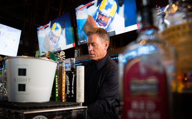 Former Dallas Cowboys quarterback and Fox News sportscaster Troy Aikman pours glasses of his new low-calorie lager, Eight, behind the bar at the Lavaca Street Bar in North Austin on Feb. 8, 2022.