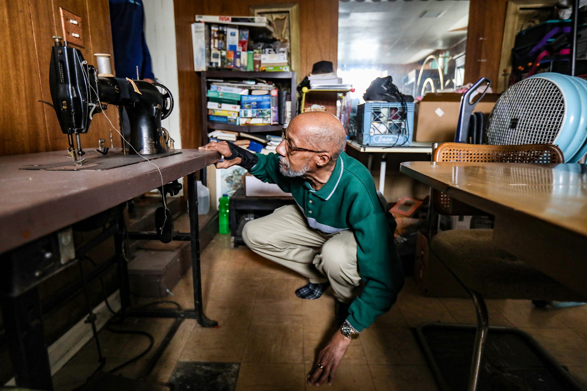 Adrian Ponder, 73, of Royal Oak looks for the switch to turn on his late Aunt Vivan McLaughlin's sewing machine at her home in Detroit on Tuesday, Feb. 8, 2022. Ponder retired from the Detroit Police Department in 1986 after witnessing his partner being shot and killed on duty. Suffering from Post Traumatic Stress Disorder, Ponder's relationship through the years with McLaughlin has helped him to heal to the point where he can perform his security job today at Wayne State University.