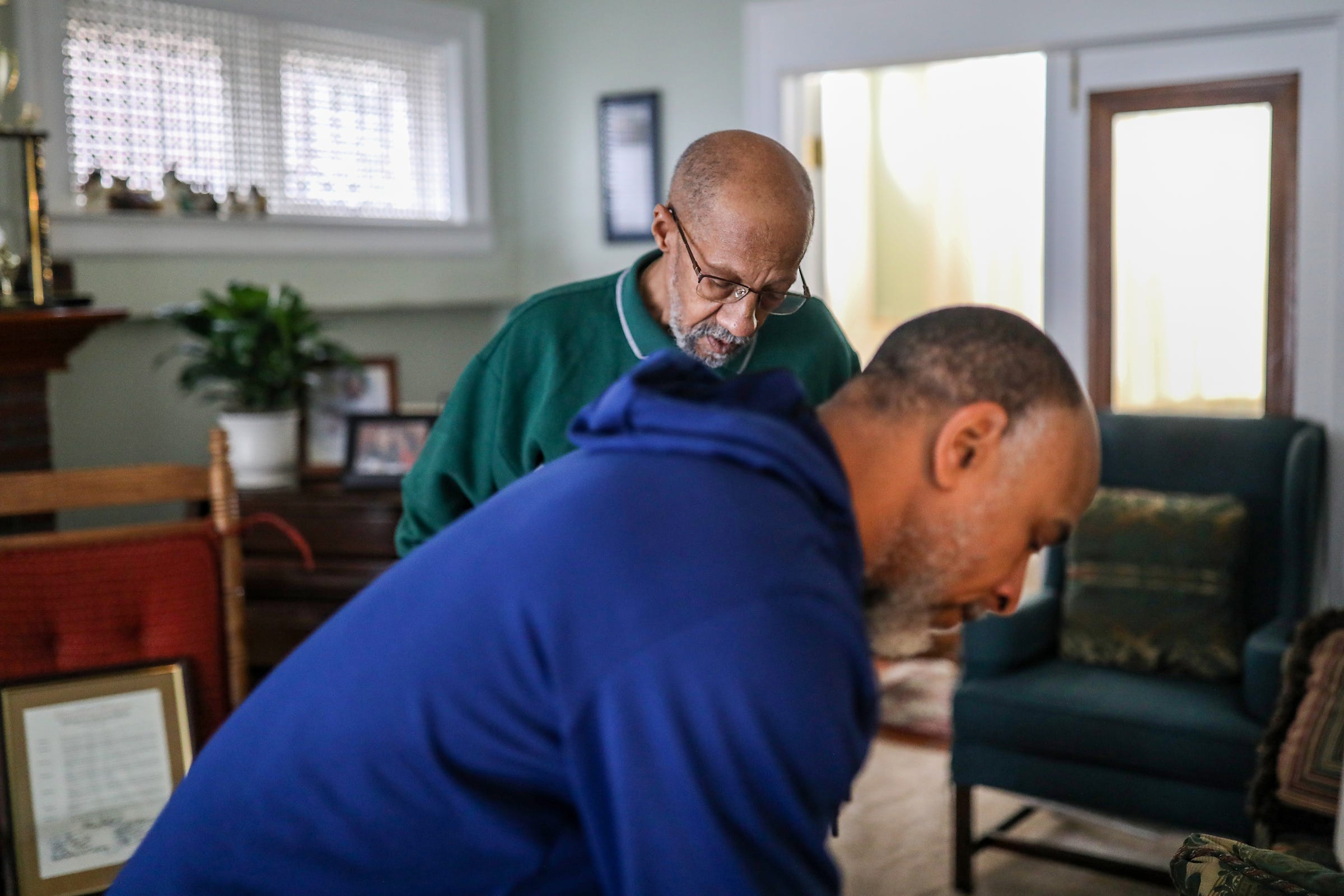 Adrian Ponder, 73, of Royal Oak looks through his late Aunt Vivan McLaughlin's things at her home with her grandson Jonathan McLaughlin in Detroit on Tuesday, Feb. 8, 2022. Ponder retired from the Detroit Police Department in 1986 after witnessing his partner being shot and killed on duty. Suffering from Post Traumatic Stress Disorder, Ponder's relationship through the years with McLaughlin has helped him to heal to the point where he can perform his security job today at Wayne State University.