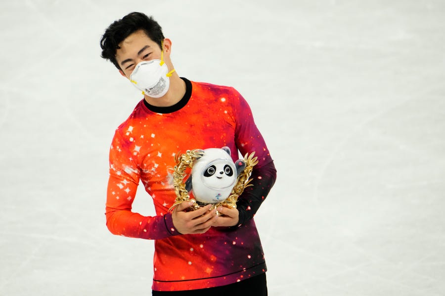Olympic gold medalist Nathan Chen holds his mascot at the 2022 Beijing Olympics.