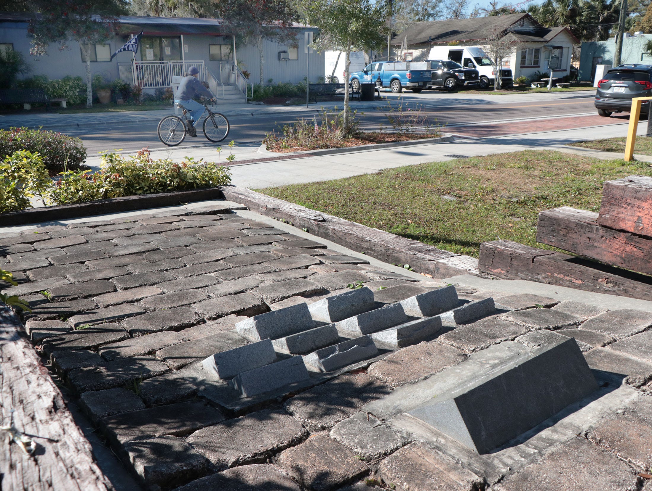 A bicyclist rides past the Goldsboro Museum and the stone markers for Trayvon Martin and others killed under questionable circumstances on Feb. 10, 2022, in Sanford, Fla.