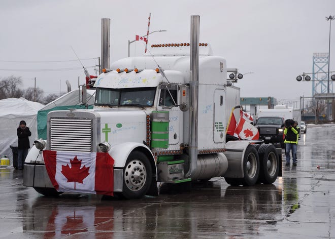 A trucker moves out of the far left lane of Huron Church Road to open a lane up from the exit of the Ambassador Bridge in Windsor, ON, on Friday, Feb. 11, 2022.