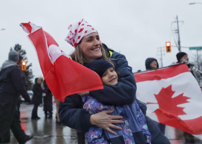 Jackie Viola hugs her daughter Sophie, 6, both of Windsor, during an anti-mandate protest on Huron Church Road in Windsor, ON, on Friday, Feb.11, 2022.