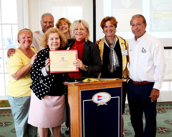 Cindy Love the President of the Rotary Club of Marco Island Noontime is shown in the center presenting the 2022 Spirit of Marco Island Award to Lynne Minozzi.