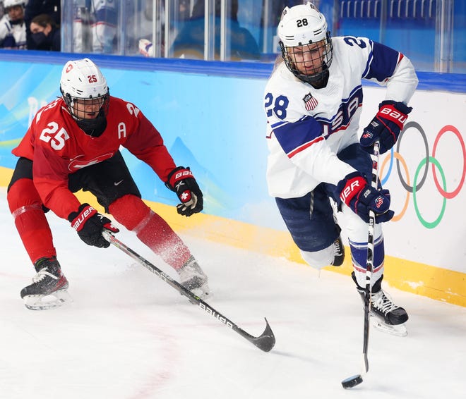 Amanda Kessel, right, controls the puck as Switzerland forward Alina Muller gives chase during a preliminary round match at the 2022 Beijing Olympics.