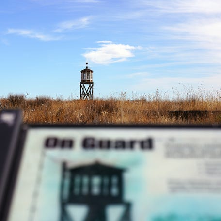 A reconstructed octagonal guard tower looms over a sign at the Amache site in Grenada, Colorado, where about 7,500 Japanese Americans, most of them U.S. citizens, were forcibly detained without due process during WWII.