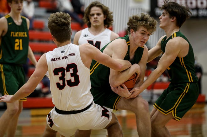 Alex Gillum of Flat Rock fights for the rebound against Milan’s Ethan Budd. Coming in to assist is Flat Rock's Corey Lannon (right). Friday night. Flat Rock clinched the Huron League championship with a 51-42 win.